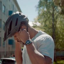 hombre con casco de bicicleta utiliza la reproducci??n de m??sica del reloj gps